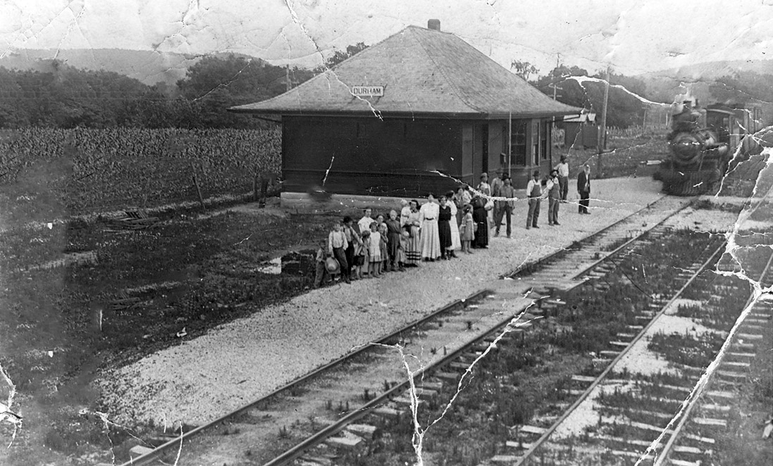 People waiting beside railroad tracks
