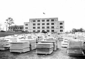 Large stacks of white marble squares sitting in front of white marble building