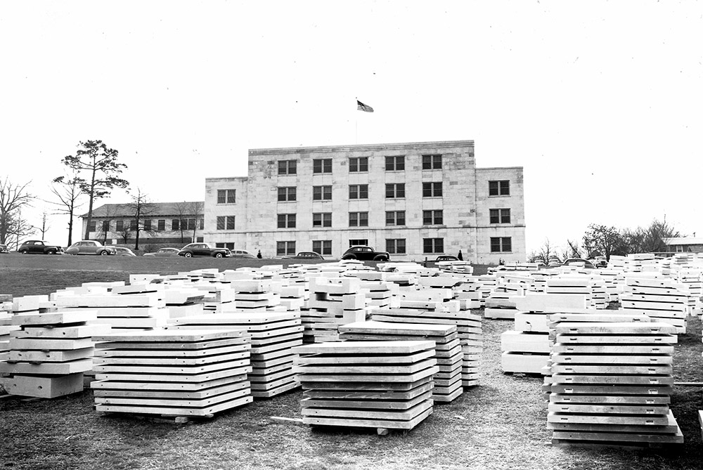 Large stacks of white marble squares sitting in front of white marble building