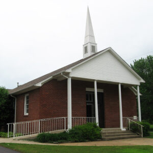 Red brick church building with small white columns