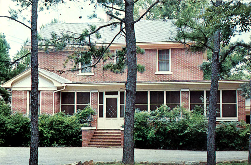 Multistory red brick building with screened porch