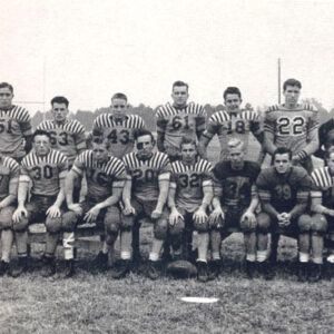 Group of white male football players seated on bleachers