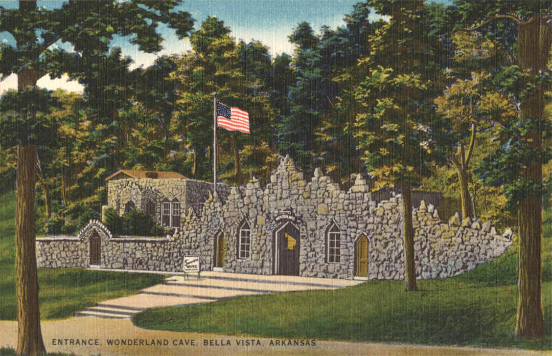 Rock building with American flag surrounded by trees