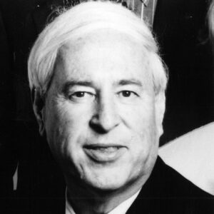 White man with white hair in suit and tie