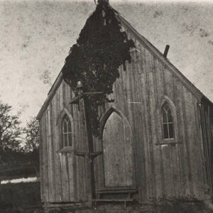 Wooden church building with ivy growing on the front