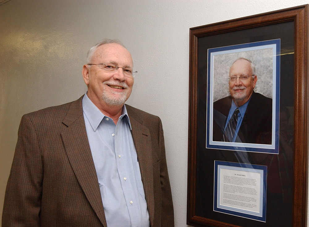 White man standing next to framed portrait of himself