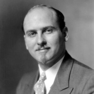 White man in suit with mustache and goatee