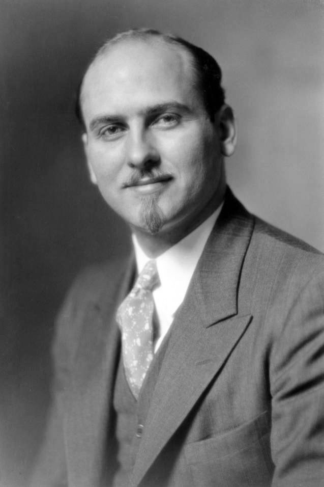 White man in suit with mustache and goatee
