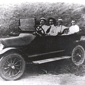 Three men in hats and a woman sitting in convertible