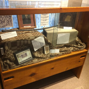 Museum exhibit of photos and clippings in a glass case