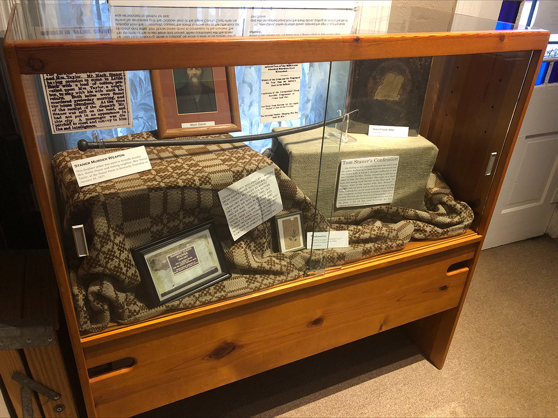 Museum exhibit of photos and clippings in a glass case