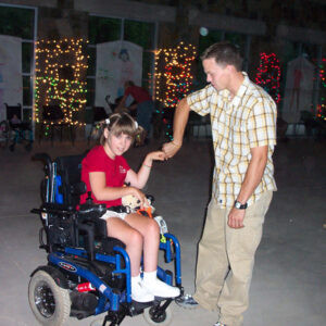 White girl in wheelchair dancing with white man standing