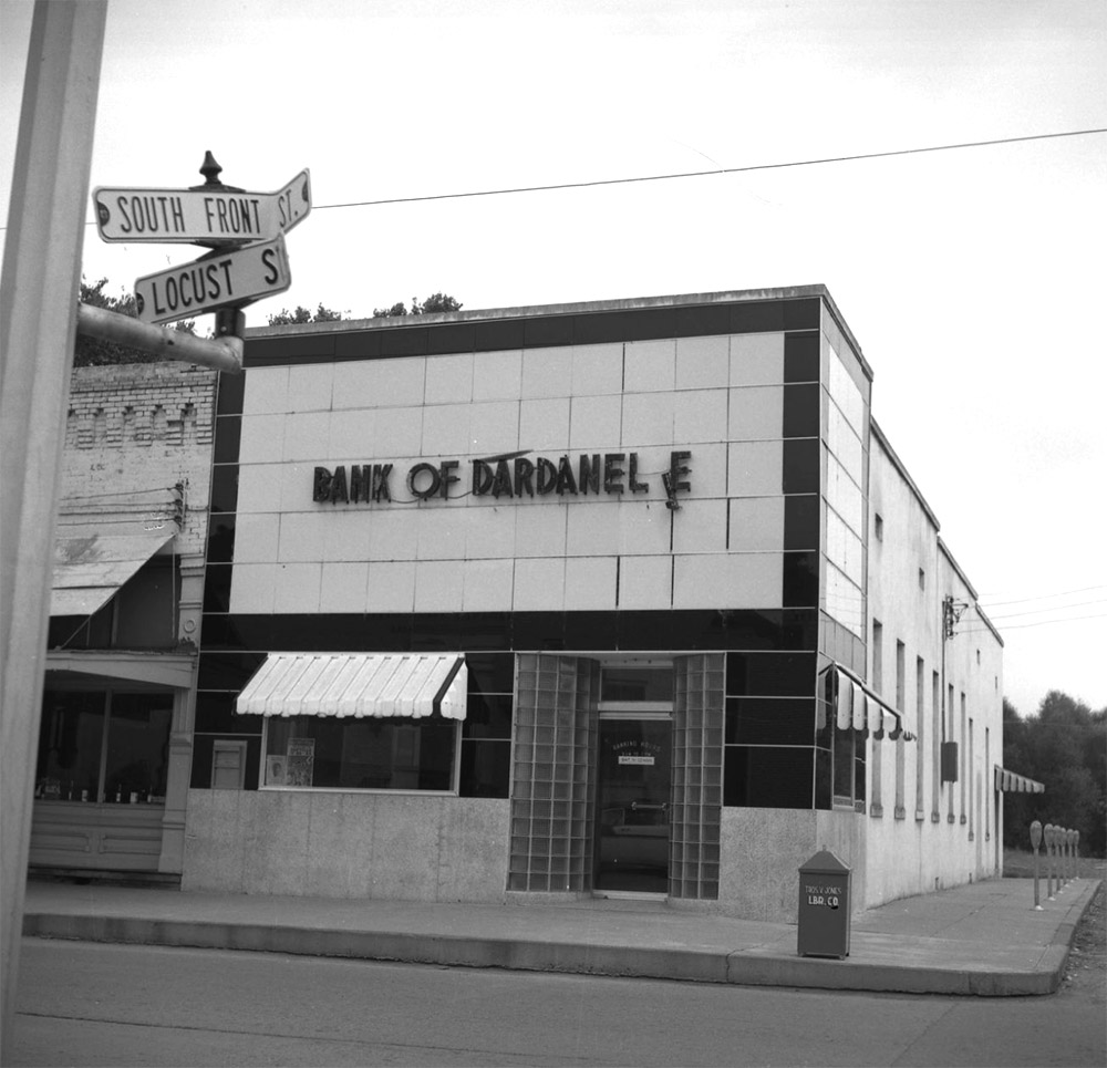 Multistory concrete building with sign saying "Bank of Dardanelle" with the second letter L in Dardanelle hanging