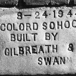 Concrete plaque embedded in brick building reading "Colored School Built by Gilbreath and Swan."