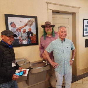 Group of three men in hallway next to water fountain