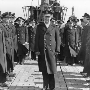 White men in military garb standing on the deck of a ship