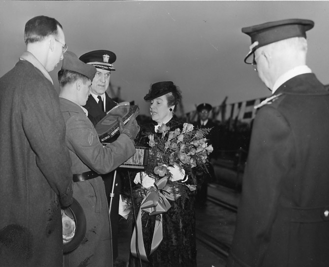 White military men and white woman holding flowers
