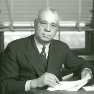 African American man in suit and tie holding pen and paper