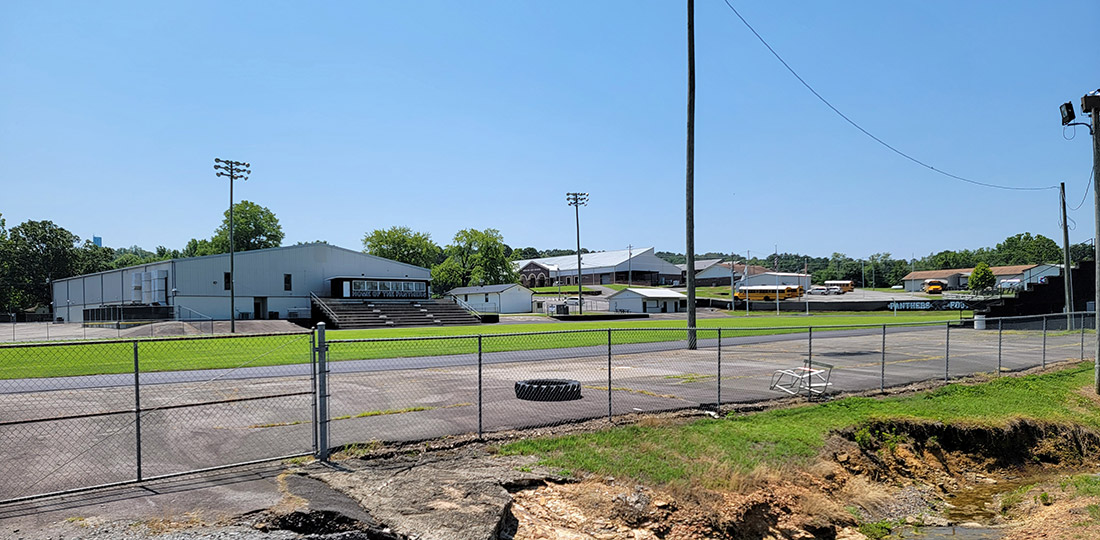 School buildings and sports track with bleachers and lights