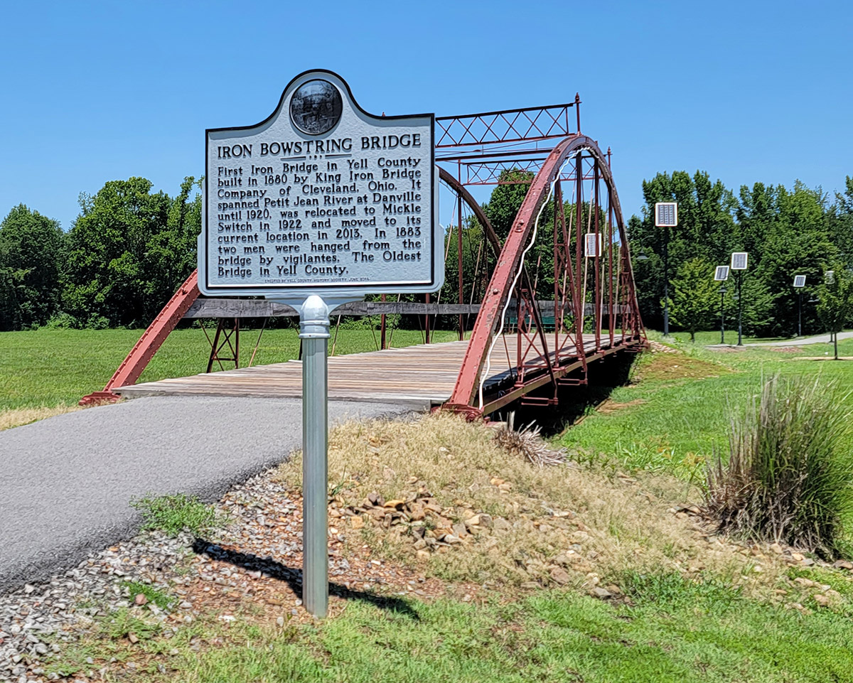 Metal bridge crossing no water. Sign adjacent