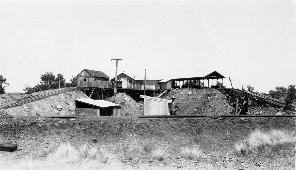 Wooden and metal buildings on mound of dirt and below it