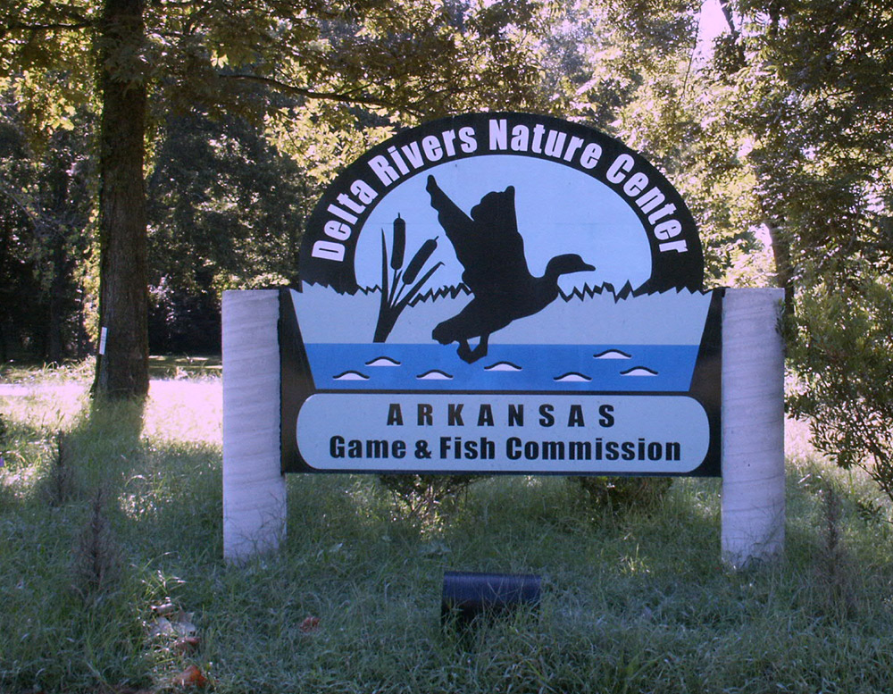 Wooden sign featuring a duck and words saying "Delta Rivers Nature Center"