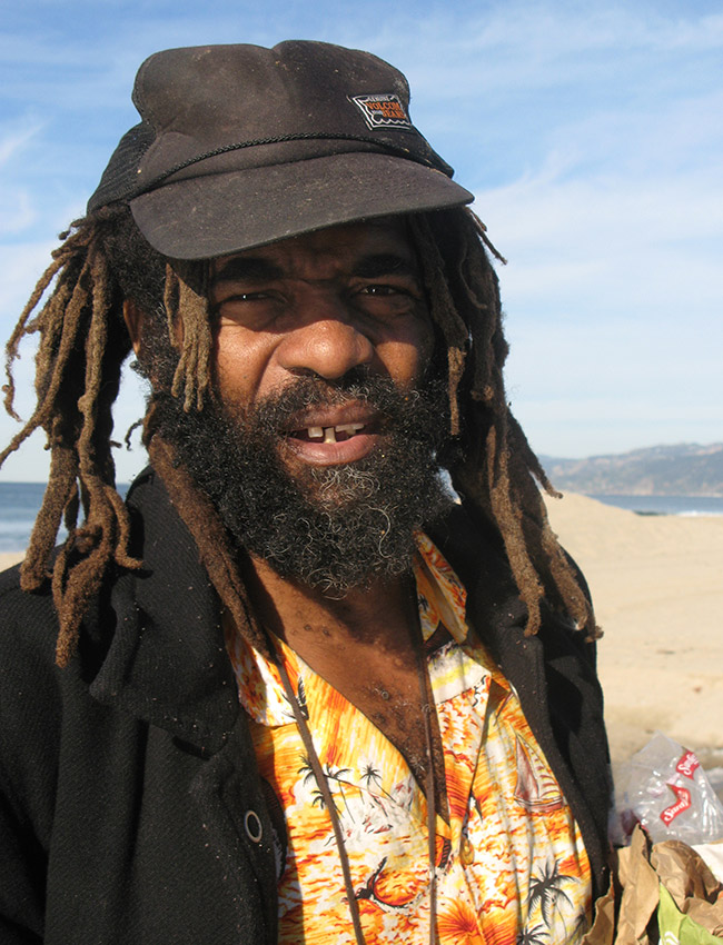 Bearded African American man with dreadlocks and cap