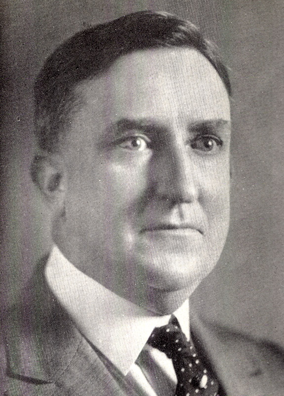 White man in suit jacket and tie