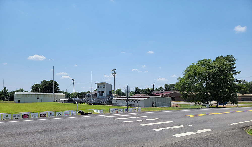 School buildings and sports track with bleachers and lights