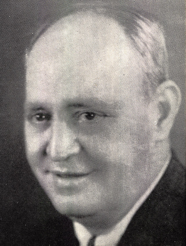 White man with receding hairline in suit and tie