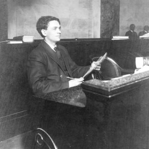 White man sitting at a long desk