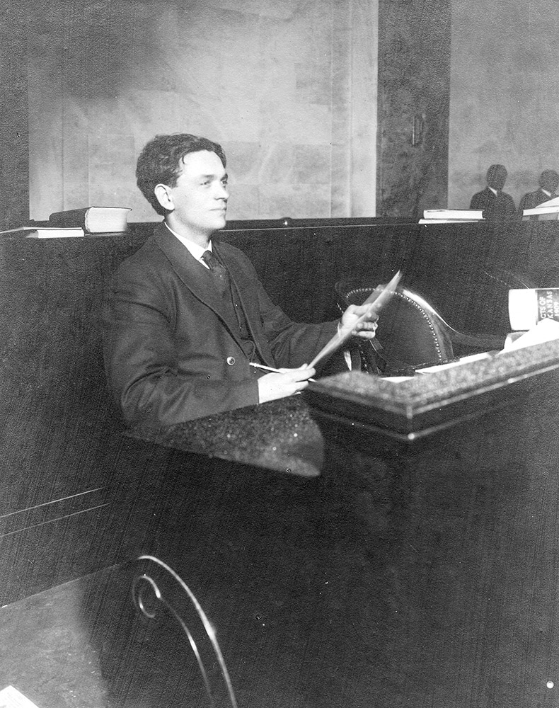 White man sitting at a long desk
