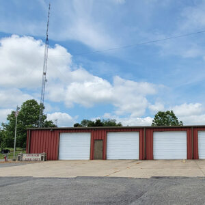 Single story red metal building with five garage doors