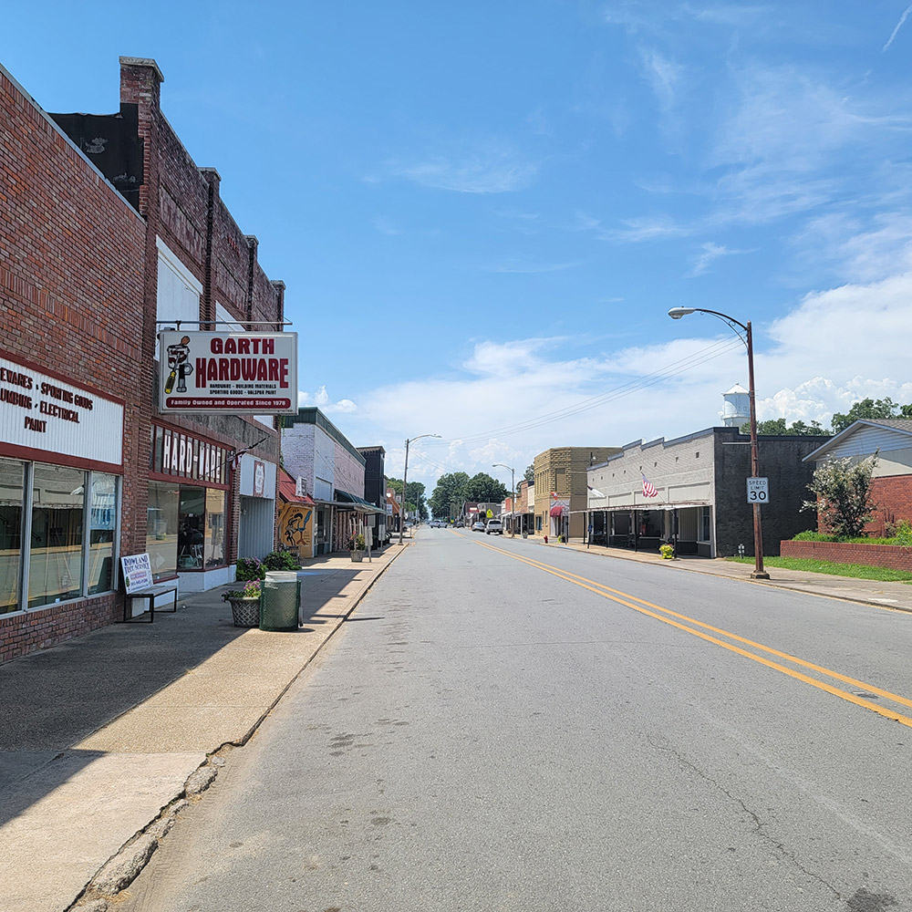 Small town street with storefront buildings on both sides of the road