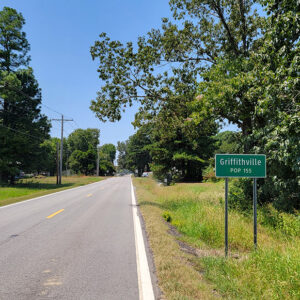 Tree-lined road and sign saying "Griffithville"