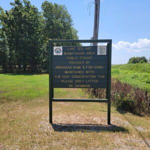 Sign saying "Lake Des Arc Bankfishing Area" with additional text about Arkansas Game and Fish and a maintenance tax