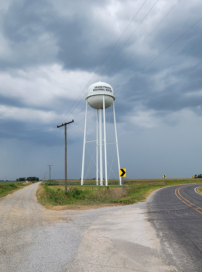 white water tower at the fork in the road printed with "Grand Prairie Regional Water"
