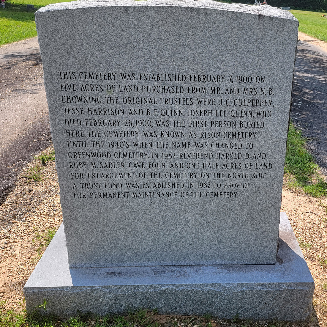 Concrete monument engraved with details about the establishment of the cemetery on February 7