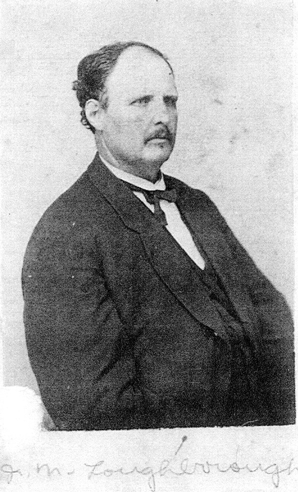 White man with mustache in suit and cravat