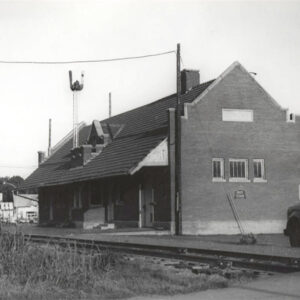 Multistory brick building beside railroad tracks