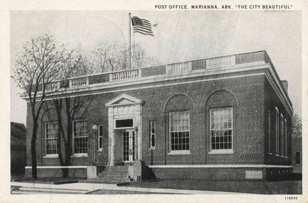 Single story brick building with American flag on roof on pole