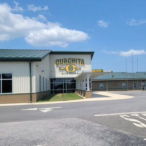 Brick and metal building with "Ouachita High School" on the front with a yellow "O" with an arrow going through it