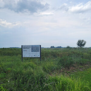 Grassy landscape with sign saying "Railroad Prairie Natural Area"