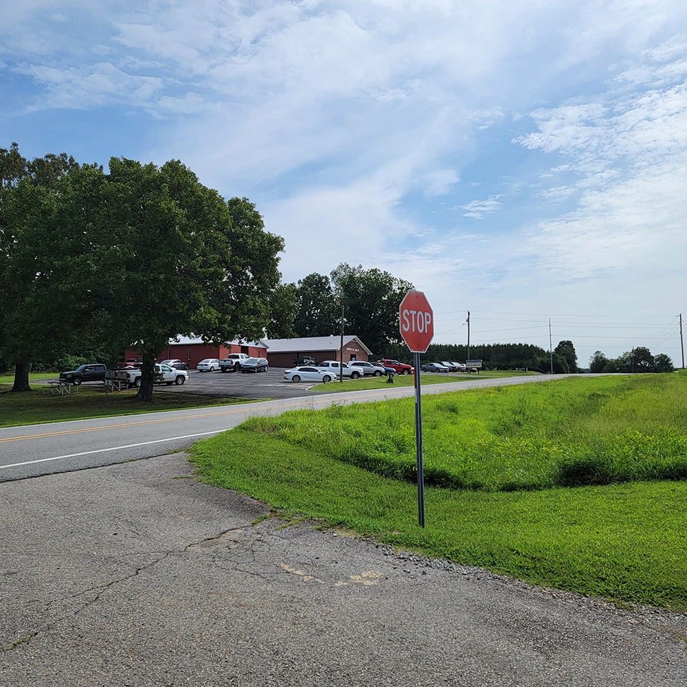 Stop sign at intersection with county road and buildings