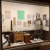 Museum exhibit of old barbershop items displayed behind a window