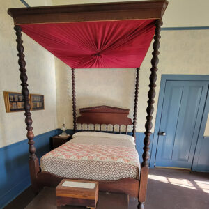 Wallpapered room with antique canopy bed