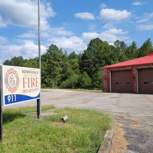 Single story red brick building with bay doors and sign "Bonnerdale Fire Department"
