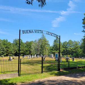 Cemetery with graves behind fence with arched entrance saying "Buena Vista Cemetery"
