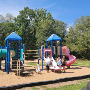 Children and adults at a playground with colorful equipment