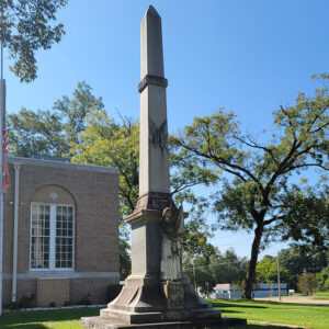 Statue and obelisk in front of building